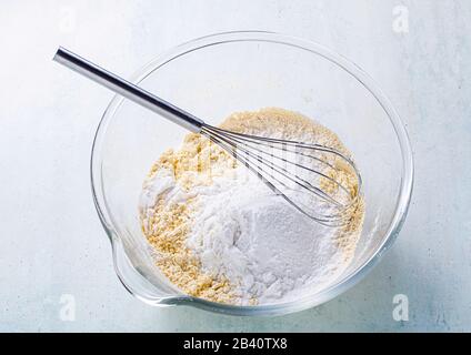 mélanger les ingrédients secs dans un bol en verre avec un fouet Banque D'Images