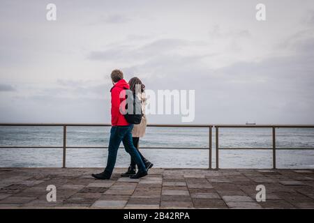 Un couple marchant le long de la côte près de Cascais, Portugal Banque D'Images