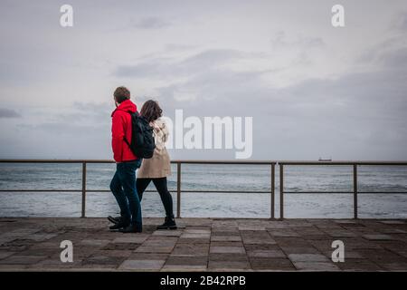 Un couple marchant le long de la côte près de Cascais, Portugal Banque D'Images