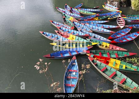 Groupe de bateaux de pêche multicolores vue aérienne sur l'eau douce du lac Phewa ou Fewa à Pokhara, au Népal Banque D'Images
