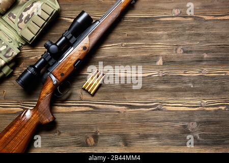Fusil de chasse et munitions sur fond en bois sombre.vue sur le dessus. Banque D'Images