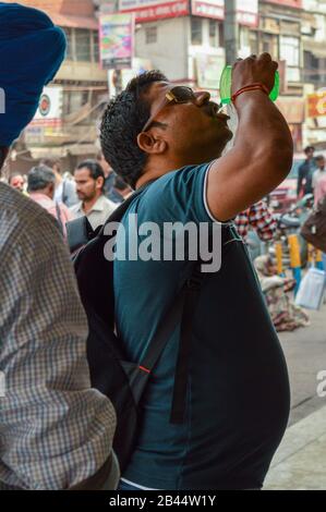 Un homme indien qui boit de l'eau au stand de service gratuit de l'eau. Banque D'Images