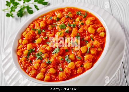 Plat végétarien : masala de chana indien ou curry de pois chiches aux épices de masala de garam, sauce tomate, feuille de laurier, saupoudrée de persil servi sur une assiette Banque D'Images