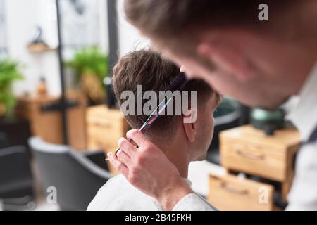 Le jeune homme a couper les cheveux au salon de coiffure Banque D'Images