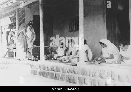 Mahatma Gandhi et ses associés mangeant dîner à Seagram Ashram, Vardha, Maharashtra, Inde, Asie, novembre 1933, ancienne image du XXe siècle Banque D'Images