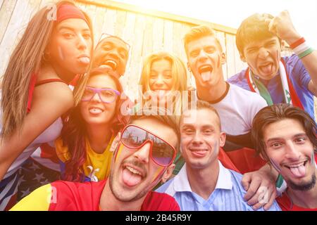 Les supporters de football multinationaux qui prennent des selfies à l'extérieur - Heureux multiraciaux qui font des visages drôles à l'appareil photo pour les jeux olympiques - Sport contre rac Banque D'Images