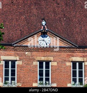 France , la ville de Seurre, département Bourgogne-Franche-Comté, horloge jacquemart sur la façade de l'école des filles. L'horloge jacquemart à Seurre est l'une des dernières en France qui continue de travailler. Les vêtements et le chapeau de l'automate Tjhe sont en tricolore français. Il repose sur un faisceau et maintient un marteau relié à l'horloge par des câbles qui le conduisent en action. Banque D'Images