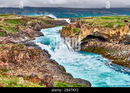 Le Goðafoss est l'une des chutes d'eau les plus spectaculaires d'Islande. Il est situé dans le district de Bárðardalur, dans le centre-nord de l'Islande, au début de la route des hautes terres de Sprengisandur. L'eau de la rivière Skjálfandafljót tombe d'une hauteur de 12 mètres sur une largeur de 30 mètres. Banque D'Images