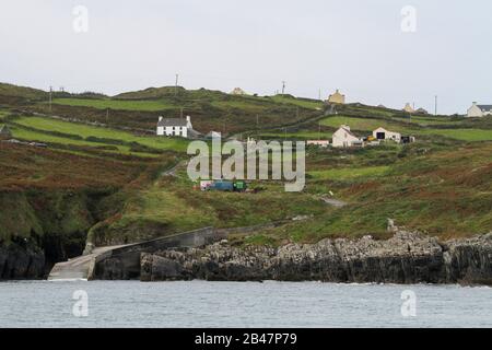 La route de campagne s'enroule à travers l'île du Cap Clear en Irlande à travers les terres agricoles de l'île pour glisser sur une rive rocheuse du côté nord-est de l'île. Banque D'Images