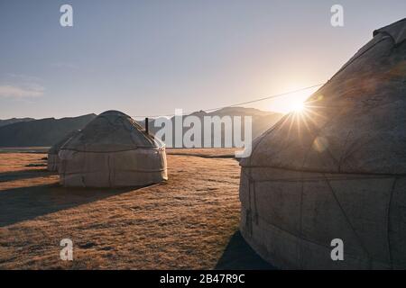 Des maisons nomades yourtes campent dans la vallée de la montagne au lever du soleil en Asie centrale Banque D'Images