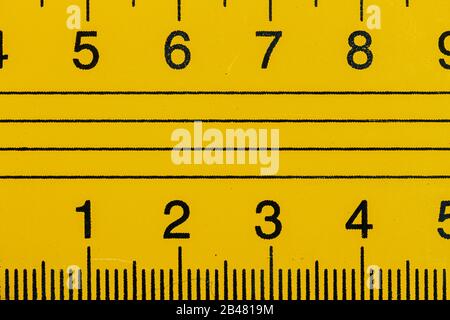 Règle métallique jaune gros plan en millimètres et centimètres Banque D'Images