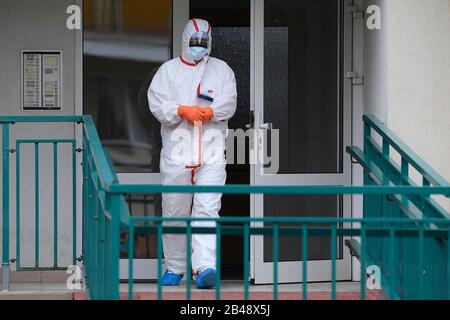 Prague, République Tchèque. 06 mars 2020. Un paramédical dans un costume de protection s'occupe d'un conteneur avec du matériel biologique recueilli dans un des ménages de Prague dans une ambulance, le 6 mars 2020, République tchèque. Dans la capitale, les travailleurs de la santé ont commencé à prélever des échantillons pour confirmer l'infection par un nouveau type de coronavirus dans les maisons des gens, tel que déterminé par la station régionale d'hygiène. Une infirmière ou un médecin viennent chez eux dans une ambulance. Crédit: Ondrej Deml/Ctk Photo/Alay Live News Banque D'Images