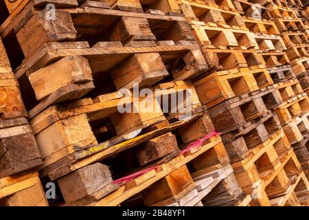 De nombreuses piles de palettes en bois d'occasion de type euro en entrepôt sont prêtes pour le recyclage. Contexte industriel. Gros plan. À L'Extérieur. Banque D'Images