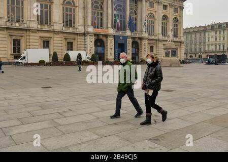 Turin, Italie. 25 février 2020. Les gens marchent tout en portant des masques à la Piazza Castello à Turin.Italie a enregistré une augmentation de 25% des cas de coronavirus en 24 heures, avec des infections qui restent centrées sur des éclosions dans deux régions du nord, la Lombardie et la Vénétie, 2.502 personnes ont été infectées par le roman Coronavirus jusqu'à présent (parmi ces 79 personnes sont mortes - principalement à cause d'une image clinique antérieure et sérieuse compromise par le virus, 2263 personnes sont actuellement positives et 160 personnes ont déjà été récupérées). La propagation marque la plus grande épidémie de l'Europe, ce qui a amené le gouvernement italien à émettre des mesures draconiennes de sécurité Banque D'Images