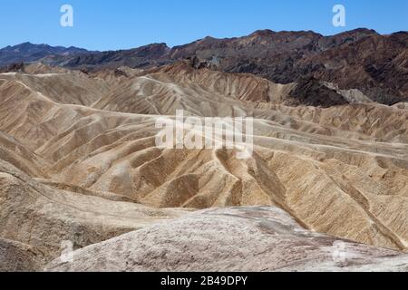 Rochers arides de Zabriskie point dans le parc national de la Vallée de la mort, avec une gamme élevée de tonalité, des tons lumineux aux vagues sombres de roches Banque D'Images