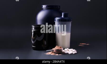 Suppléments nutritionnels sportifs sur fond noir. Forme physique, musculation, concept de mode de vie sain. Poudre de protéine de lactosérum dans la pelle de mesure. Espace de copie Banque D'Images