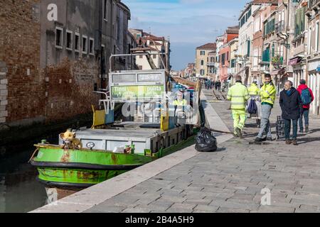 Venise, 25 février - 3 mars. 2020: Les collecteurs de déchets s'acquittent de leurs tâches normalement alors que les rues de Venise sont désertées en raison de la pandémie de Coronavirus. Les rues et les Piazza sont vides, à part une poignée de touristes et de gens du coin qui font leurs affaires quotidiennes. De nombreux touristes annulent leur visite par peur de prendre le virus. Les touristes du Japon et d'autres pays de l'Extrême-Orient comme Taiwan portent souvent des masques chirurgicaux comme mesure préventive. Banque D'Images