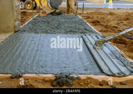 Mason la construction d'une couche de béton de ciment à mise au point sélective travaux sol béton coulée. Banque D'Images