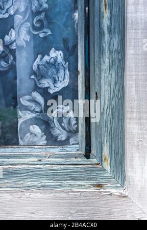 Rideau bleu suspendu dans une fenêtre en bois tissée Banque D'Images