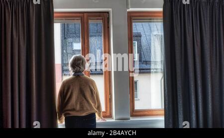 Femme d'âge moyen regardant les fenêtres Banque D'Images