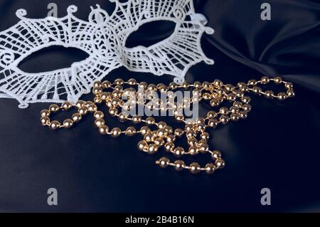 Masque carnaval blanc et perles sur fond noir. Accessoire pour carnaval. Banque D'Images