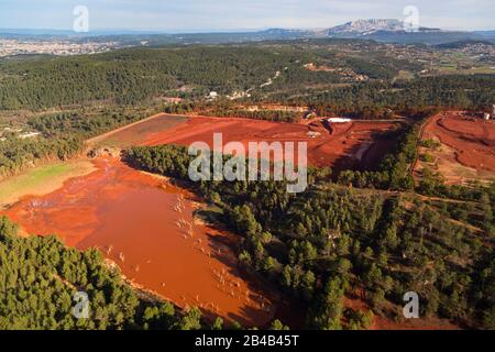 France, Bouches du Rhône, Gardanne, site de Mange Garri à Bouc Bel Air où les résidus de bauxite sont traités par deux presses à filtre de l'usine Alteo pour la production d'alumine calcinée à partir de bauxite, couleur ocre, Importés de Guinée dont les effluents liquides chargés de soda et de métaux lourds sont déversés dans le parc national de Calanques de Marseille, ville d'Aix en Provence et montagne Sainte Victoire en arrière-plan (vue aérienne) Banque D'Images