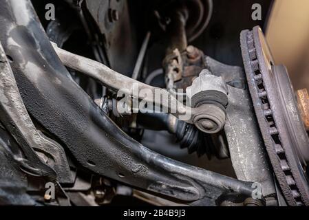 Stabilisateur de direction connecté au porte-fusée de direction, vu du bas de la voiture sur un cric dans l'atelier. Banque D'Images