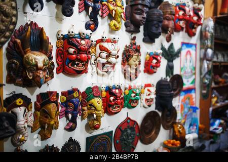 Des masques sculptés colorés sont vendus au Népal, des masques colorés de différents parfums accrochent sur le mur. Banque D'Images