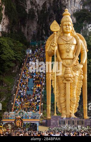 Malaisie, Etat de Selangor, Grottes de Batu, festival hindou procession de Thaipusam, célébration de dieu Murugan, fils de Shiva et Parvati, foule de pèlerins marchant les escaliers et statue dorée géante de Dieu Murugan Banque D'Images