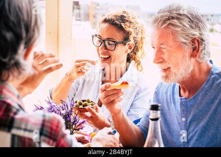 Les gens qui s'amusent ensemble pendant le déjeuner en amitié - les femmes d'âge mixte et une alimentation en activité familiale - les adultes caucasiens rient et sourient pour de belles activités Banque D'Images