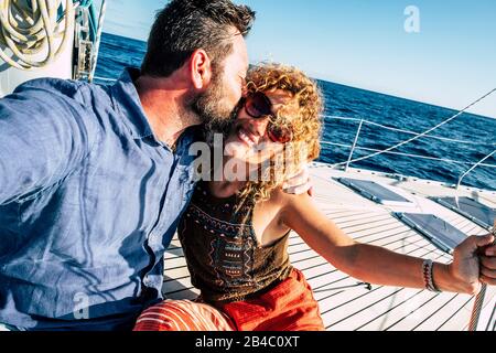 Heureux touriste couple de voyageurs personnes amoureux profiter de la croisière en bateau à voile ensemble s'amuser et sourire - homme et femme joyeux d'adulte sous le soleil d'été en vacances en mer Banque D'Images