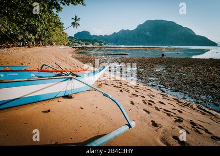 Vue sur la baie de El Nido avec banca local voile à l'avant à marée basse, un paysage pittoresque dans l'après-midi, Palawan, Philippines. Banque D'Images