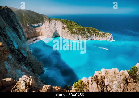 Plage Navagio, île de Zakynthos, Grèce. Des bateaux touristiques visitant la baie de Shipwreck avec de l'eau azure et une plage de sable blanc paradisiaque. Célèbre site touristique dans le monde. Banque D'Images