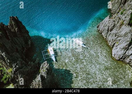 Prise de vue aérienne des îles Philippines à Palawan. Banca bateaux le matin peu profond eau propre aux rochers. Banque D'Images