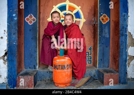 Des moines drôles avec une bouteille de gaz de butane dans le monastère de Gangtey, la vallée de Phobjikha, le Bhoutan occidental, Asie Banque D'Images