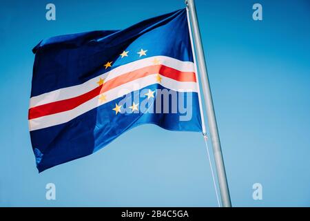 Drapeau du Cap-Vert agitant sur le mât avec fond bleu ciel. Banque D'Images