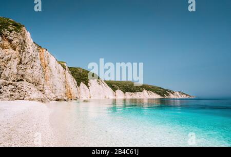 Plage de Fteri sur l'île de Céphalonie, Grèce. L'une des plus belles plages de galets non touchées avec de l'eau émeraude pure d'azure entourée de falaises rocheuses blanches élevées de Céphalonie. Banque D'Images