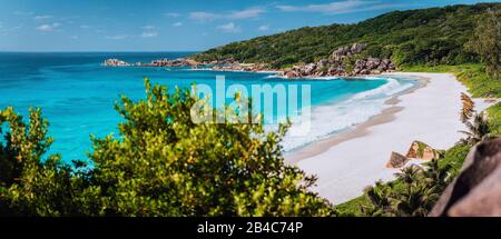 Panorama de la plage épique de Grand Anse sur l'île de la Digue, Seychelles. Plage de sable blanc, grandes vagues de l'océan et rochers de granit uniques le long de la côte. Concept de vacances d'été et de voyage de vacances. Banque D'Images