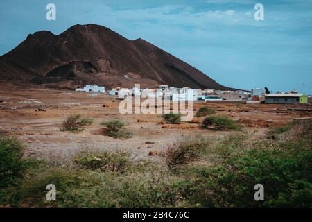 Logement local devant le cratère volcanique de Calhau, Cap-Vert - Ile de Sao Vicente. Une seule martienne comme de la roche rouge sèche se démarquent de la terre désertique stérile. Banque D'Images