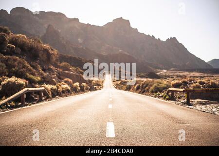 Belle et scenic long chemin route avec l'accent sur un arrière-plan et de premier plan - destination voyage avec effet sunilght et montagnes Banque D'Images