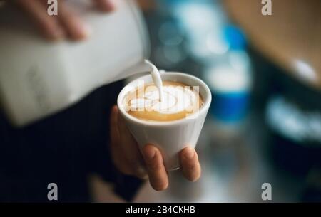 Barista pouring latte foame professionnel autour d'un café, espresso et cappuccino créer un Banque D'Images