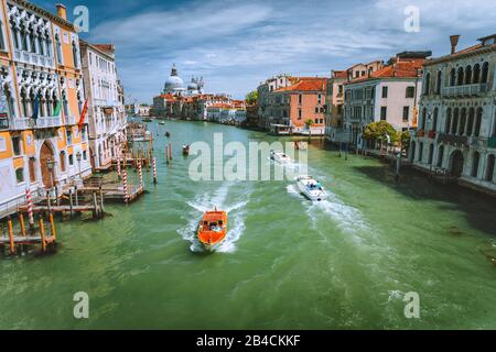 Des bateaux de tourisme de plaisir sur Grand Canal et basilique Santa Maria della Salute, Venise, Italie. Banque D'Images