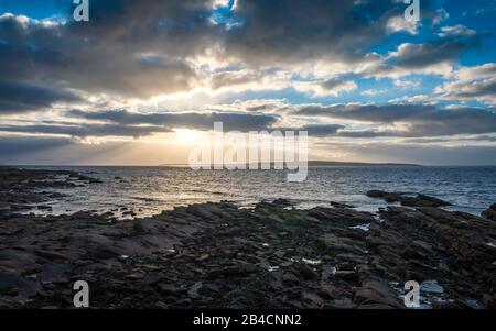 Crépuscule coucher de soleil, l'Ecosse du Nord et Le Stroma. Le littoral accidenté de John O'Groats lors d'une soirée dousoyeuse avec l'île De Stroma au loin. Banque D'Images