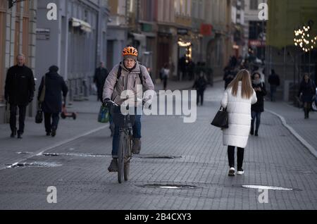 Vue latérale du jeune homme dans un équipement de protection avec sac à dos à vélo dans la rue. Banque D'Images