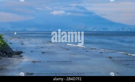 Belle vue de la soirée sur Saint Agung Vulcano à Bali de l'île Nusa Penida. Partiellement Couvert Par Les Nuages. Indonésie. Banque D'Images