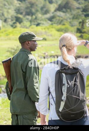 La Tanzanie du Nord, le parc national d'Arusha, un ranger armé escorte un touriste. La Tanzanie du Nord, le parc national d'Arusha, un ranger armé escorte un touriste. Banque D'Images