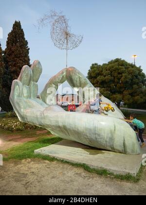 Scène de rue - les enfants jouent sur une sculpture représentant une main avec un pissenlit, prise le 24 avril 2017 dans la ville iranienne d'Ispahan. | utilisation dans le monde entier Banque D'Images