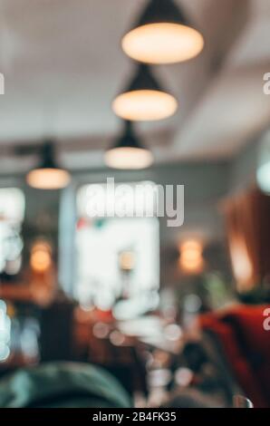 Arrière-plan flou du café avec des gens assis sur la table et la fenêtre avec bokeh Banque D'Images