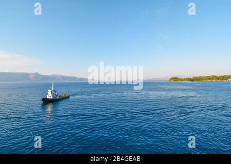 Un petit bateau pilote traverse la mer Égée vers un bateau de croisière (non visible) juste à côté de l'île de Corfou, Grèce. Banque D'Images