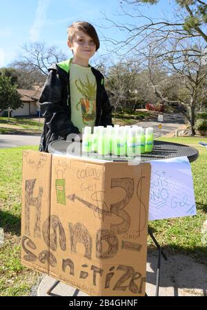 Le stand de désinfectant pour les mains remplace le stand de limonade alors que L'entrepreneur Miles Miller vend de l'aseptisant pour les mains maison pour aider à combattre le coronavirus à 3 $ la bouteille dans son Austin, Texas, quartier après l'école. Banque D'Images